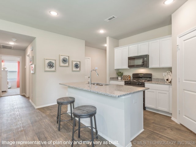 kitchen with black appliances, white cabinetry, and dark hardwood / wood-style flooring