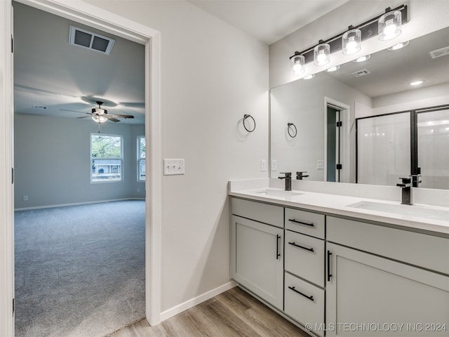 bathroom with an enclosed shower, wood-type flooring, ceiling fan, and vanity