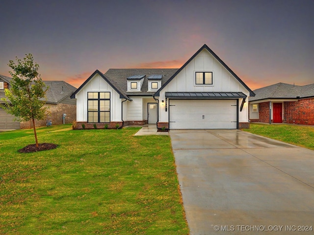 modern farmhouse featuring a lawn and a garage