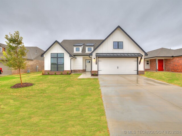 modern farmhouse style home with a front lawn and a garage