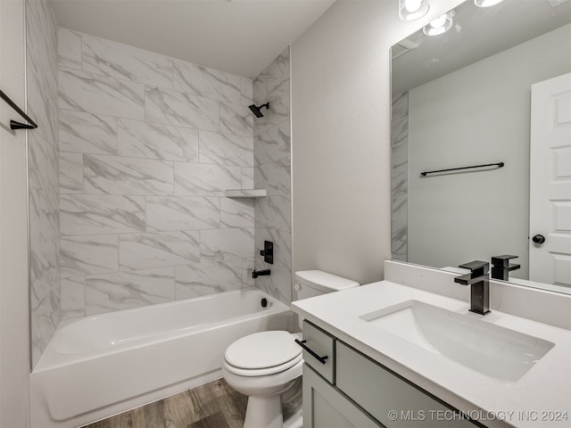 full bathroom with vanity, wood-type flooring, tiled shower / bath, and toilet