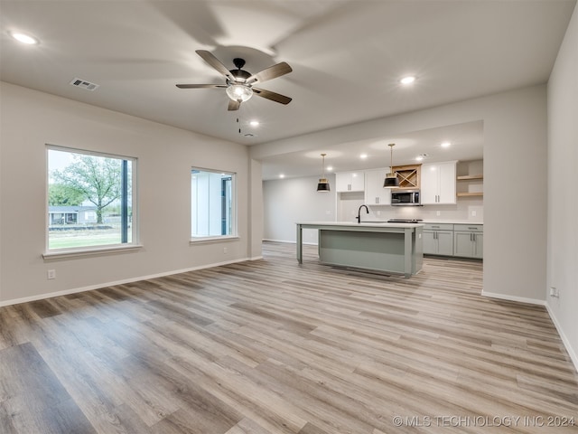 interior space featuring light wood-type flooring, sink, and ceiling fan