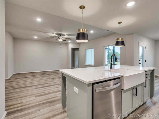 kitchen featuring a center island with sink, pendant lighting, light stone countertops, light hardwood / wood-style floors, and dishwasher