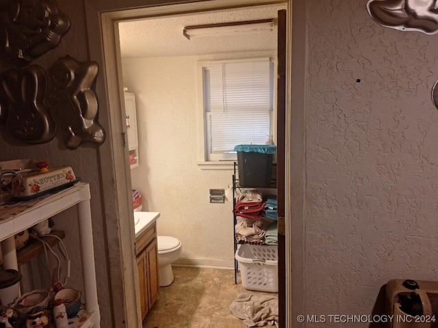 bathroom with vanity, a textured ceiling, and toilet