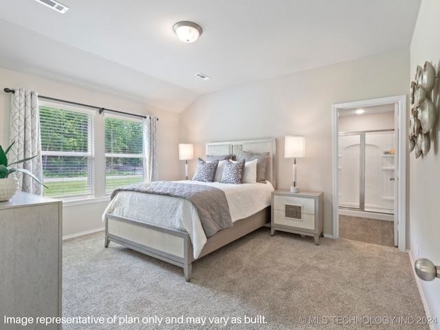 carpeted bedroom with ensuite bathroom and vaulted ceiling