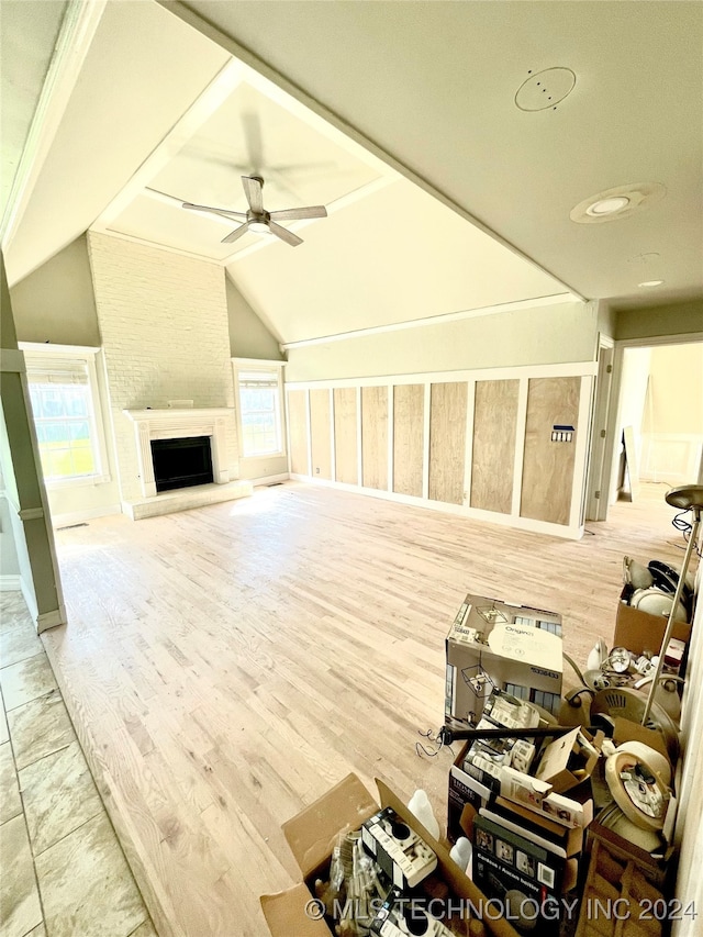 living room with lofted ceiling, a fireplace, hardwood / wood-style floors, and ceiling fan