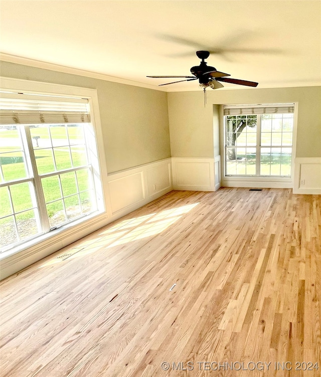 unfurnished room featuring light wood-type flooring, crown molding, ceiling fan, and a wealth of natural light