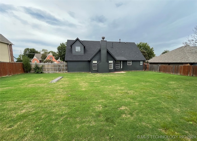 rear view of property featuring a yard