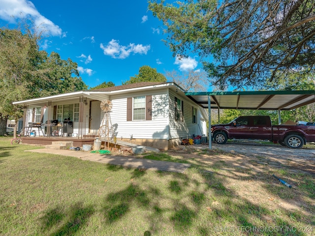 view of front of home featuring a front yard, covered porch, and a carport