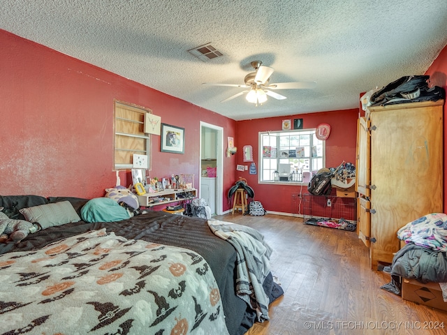 bedroom featuring wood-type flooring, ceiling fan, and a textured ceiling