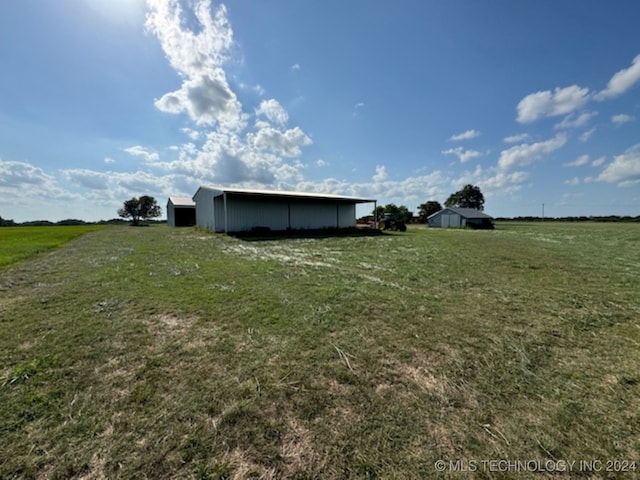 view of yard featuring a rural view and an outbuilding