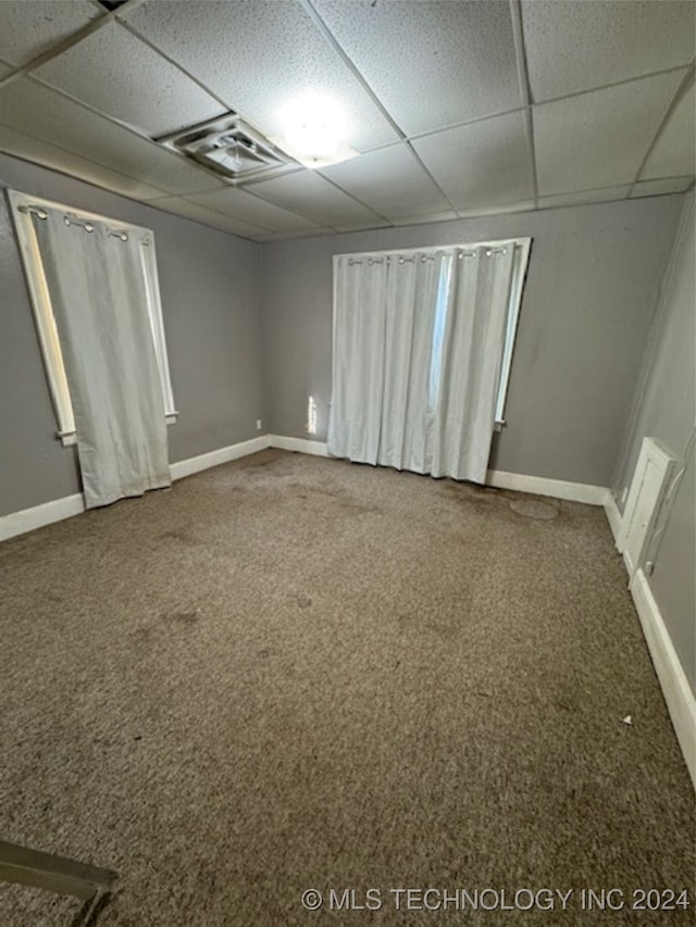 unfurnished room with carpet floors and a drop ceiling