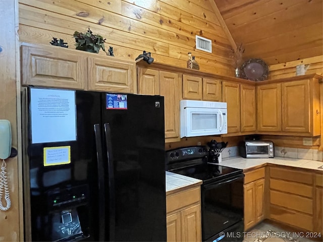 kitchen featuring lofted ceiling, wooden walls, black appliances, tile counters, and wooden ceiling