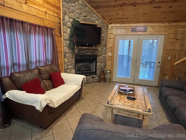 tiled living room featuring a fireplace, wood walls, wooden ceiling, lofted ceiling, and french doors