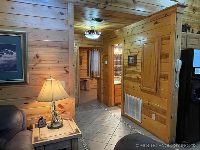 tiled living room featuring wood ceiling and wood walls