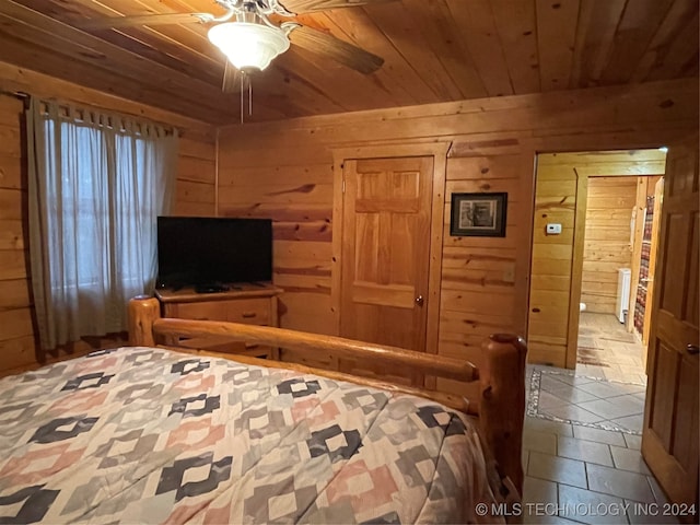 tiled bedroom with ceiling fan, wood ceiling, and wood walls