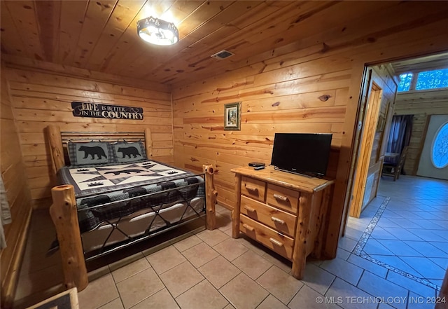 bedroom with wood ceiling, wood walls, and light tile patterned floors