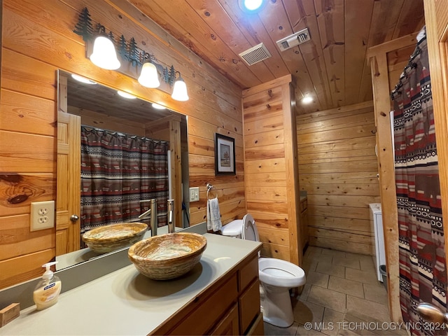 bathroom featuring vanity, wood walls, toilet, and wooden ceiling