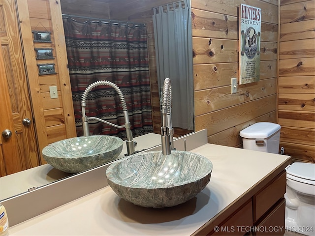 bathroom featuring wood walls, a shower with curtain, vanity, and toilet