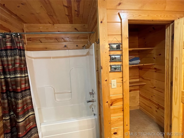 bathroom with wood ceiling, shower / tub combo with curtain, wood walls, and tile patterned floors