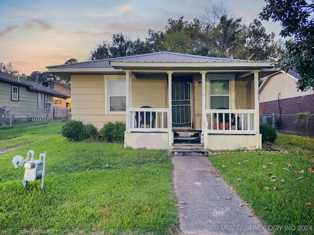 bungalow-style home featuring a yard and covered porch