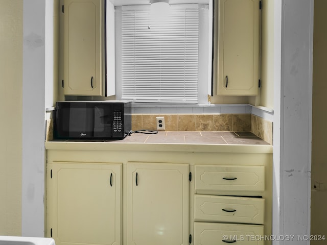 kitchen featuring cream cabinets and tile countertops