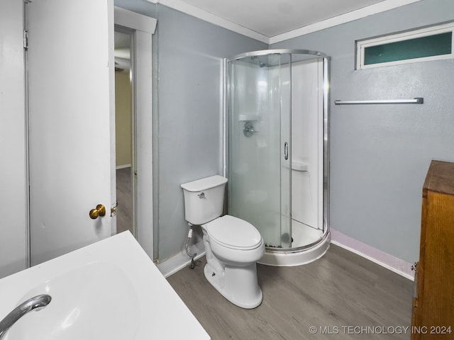 bathroom featuring wood-type flooring, sink, an enclosed shower, and toilet