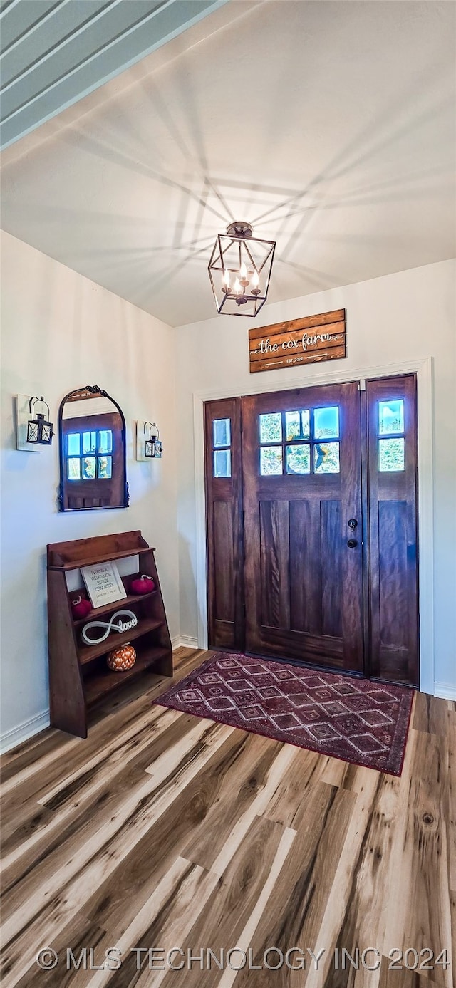 entrance foyer with wood-type flooring, an inviting chandelier, and plenty of natural light