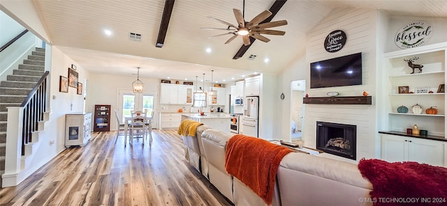 living room featuring light hardwood / wood-style floors, high vaulted ceiling, wooden ceiling, beam ceiling, and ceiling fan