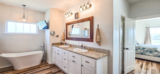 bathroom with vanity, hardwood / wood-style flooring, and a tub