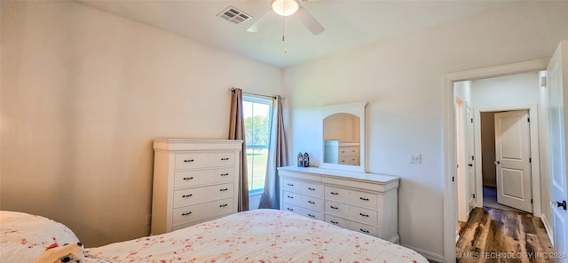 bedroom with dark hardwood / wood-style flooring and ceiling fan