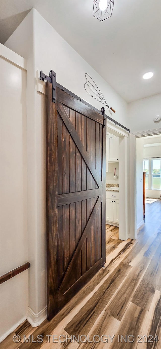 interior space with a barn door and hardwood / wood-style floors