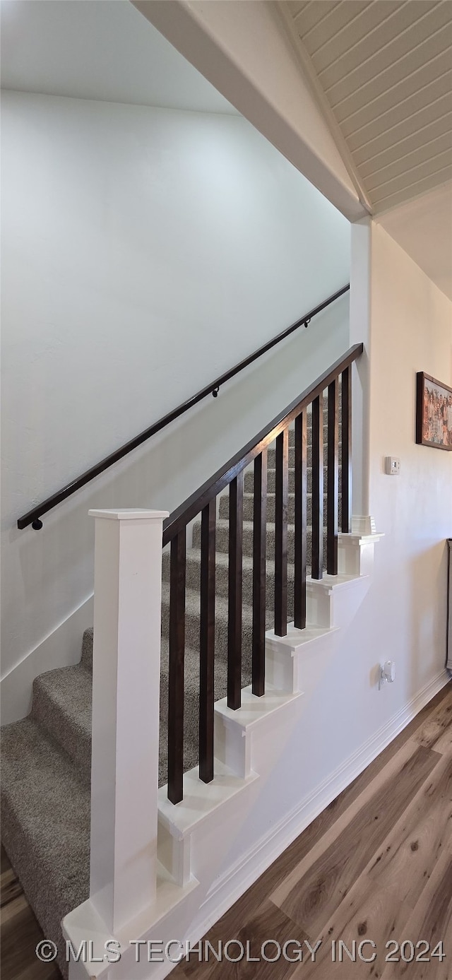 stairs with lofted ceiling and hardwood / wood-style flooring