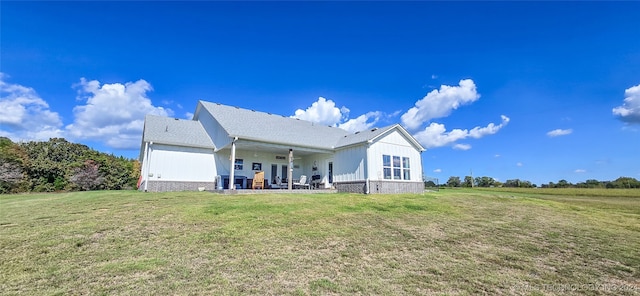 back of property with a lawn and a patio area