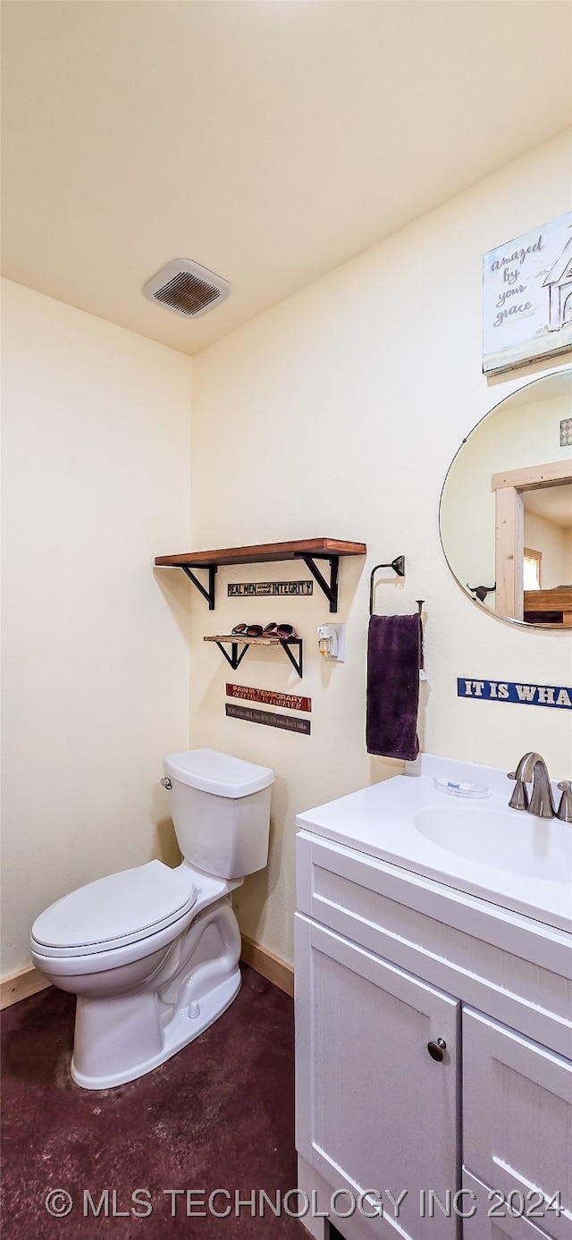 bathroom featuring concrete floors, vanity, and toilet