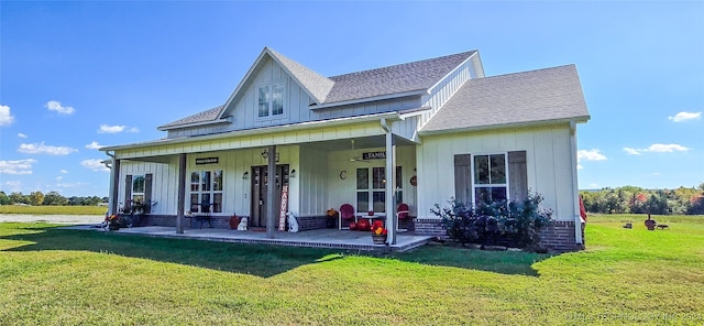 back of house with a lawn and covered porch