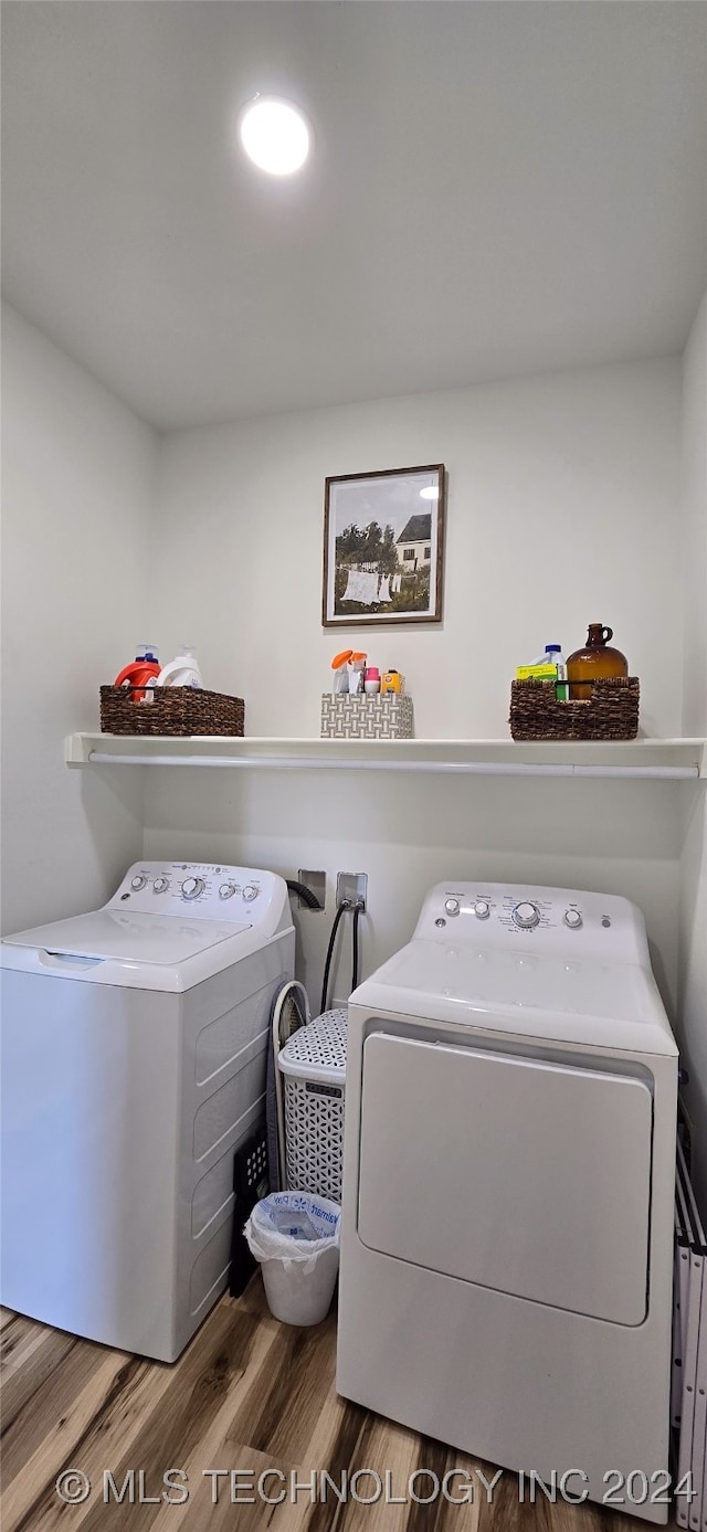 washroom featuring wood-type flooring and washing machine and clothes dryer