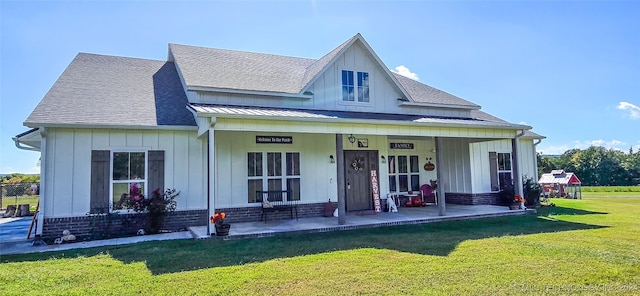 rear view of house featuring a yard and a porch