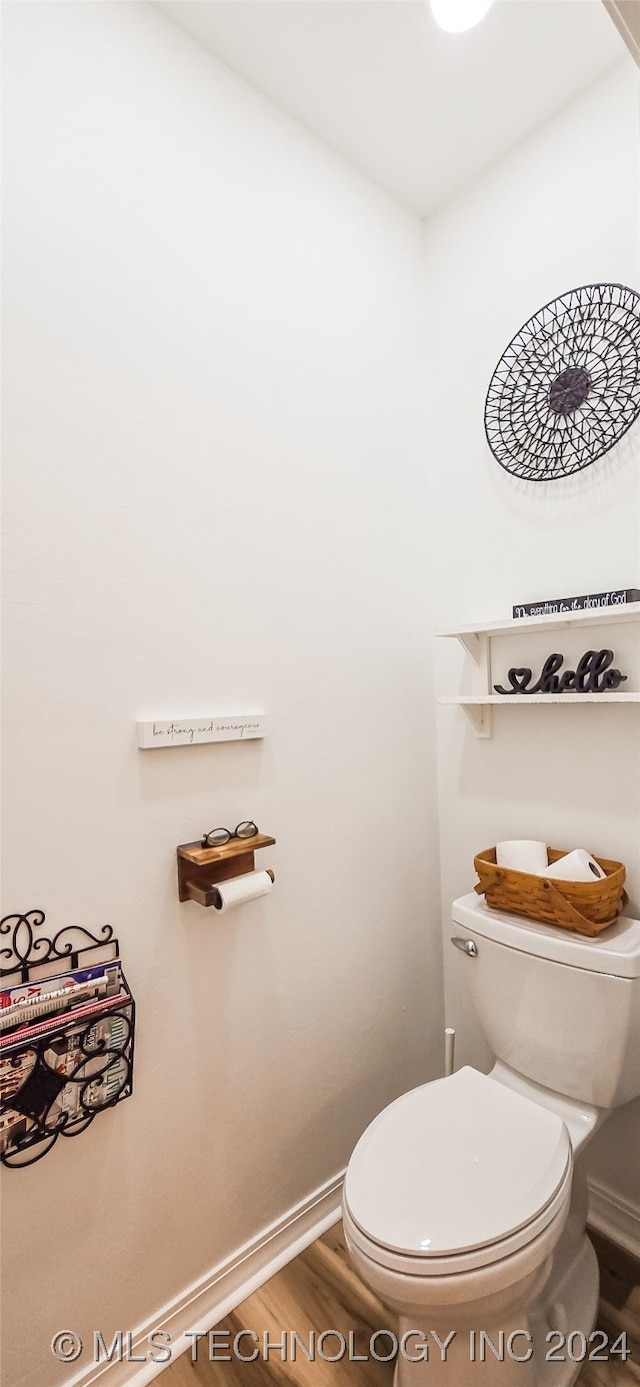 bathroom with hardwood / wood-style flooring and toilet