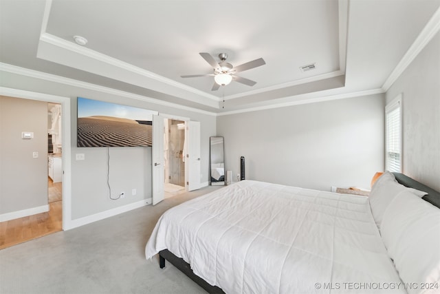 carpeted bedroom with ensuite bath, ceiling fan, and a raised ceiling