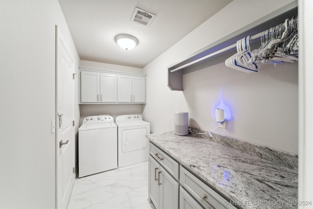 laundry room featuring cabinets and washer and dryer