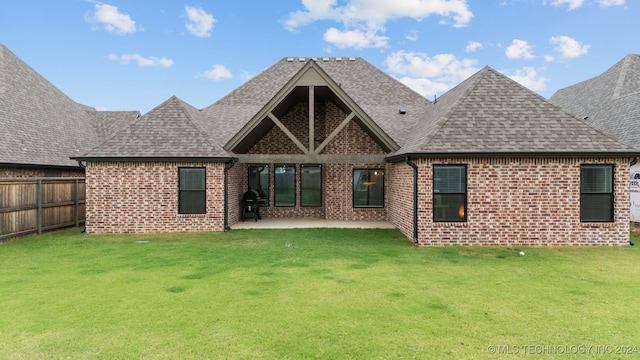 back of house with a lawn and a patio area