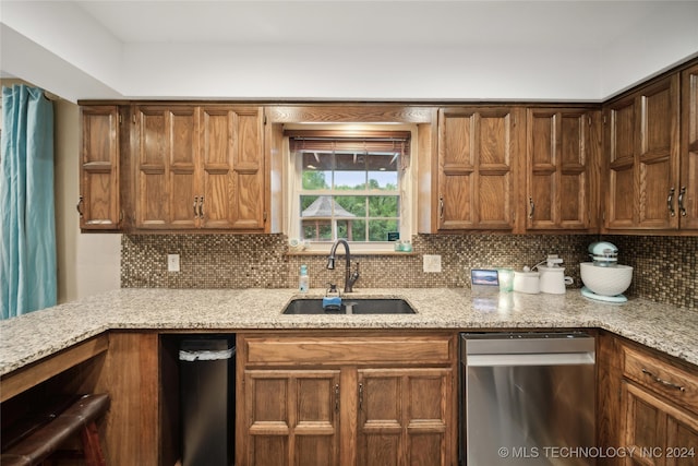 kitchen featuring decorative backsplash, sink, and light stone counters