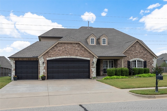 view of front of property featuring a front yard and a garage