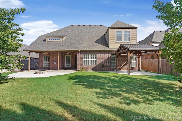 back of property with a gazebo, a patio, a fire pit, and a lawn