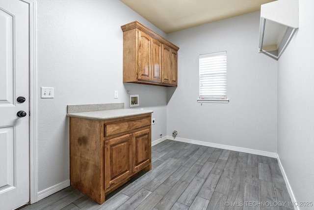 clothes washing area with hookup for a washing machine, light hardwood / wood-style flooring, cabinets, and hookup for an electric dryer