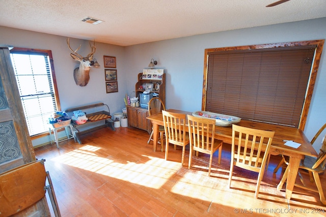 dining room featuring a textured ceiling and light hardwood / wood-style floors