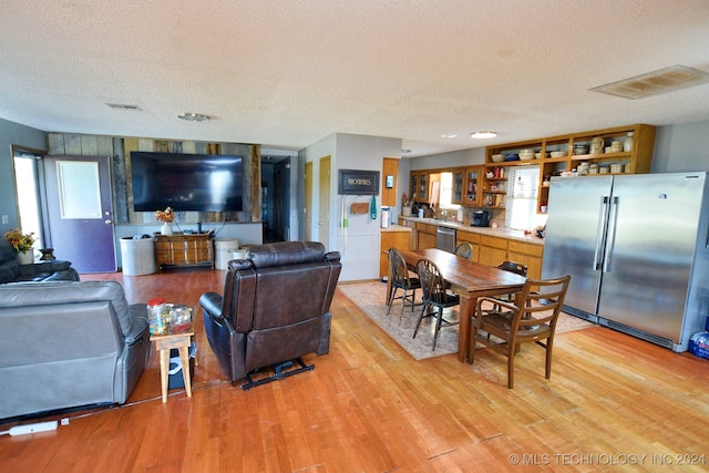 living room with a textured ceiling and light hardwood / wood-style floors