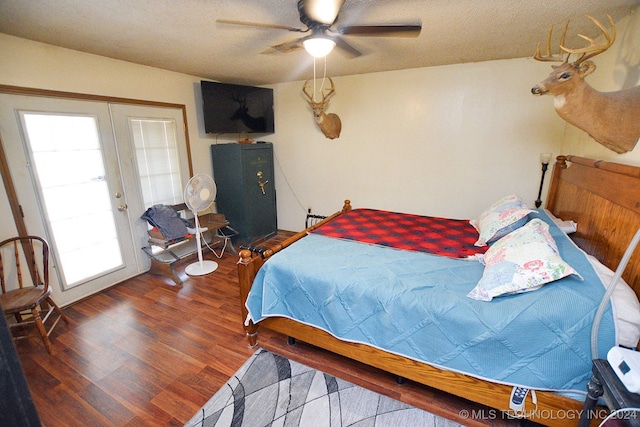 bedroom with a textured ceiling, dark hardwood / wood-style flooring, ceiling fan, and french doors