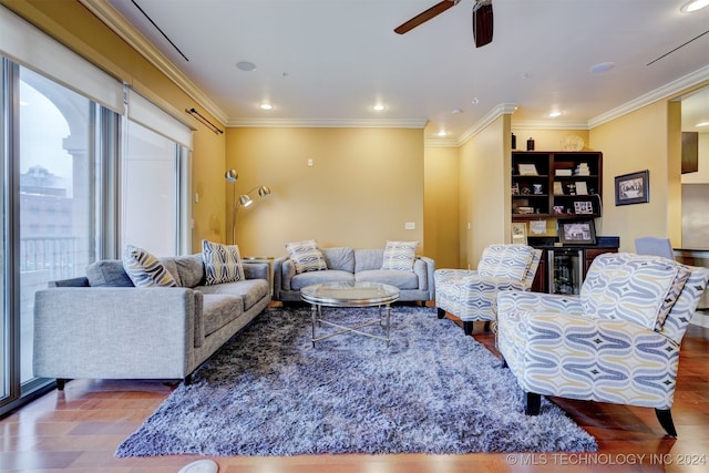 living room featuring ceiling fan, hardwood / wood-style flooring, and crown molding